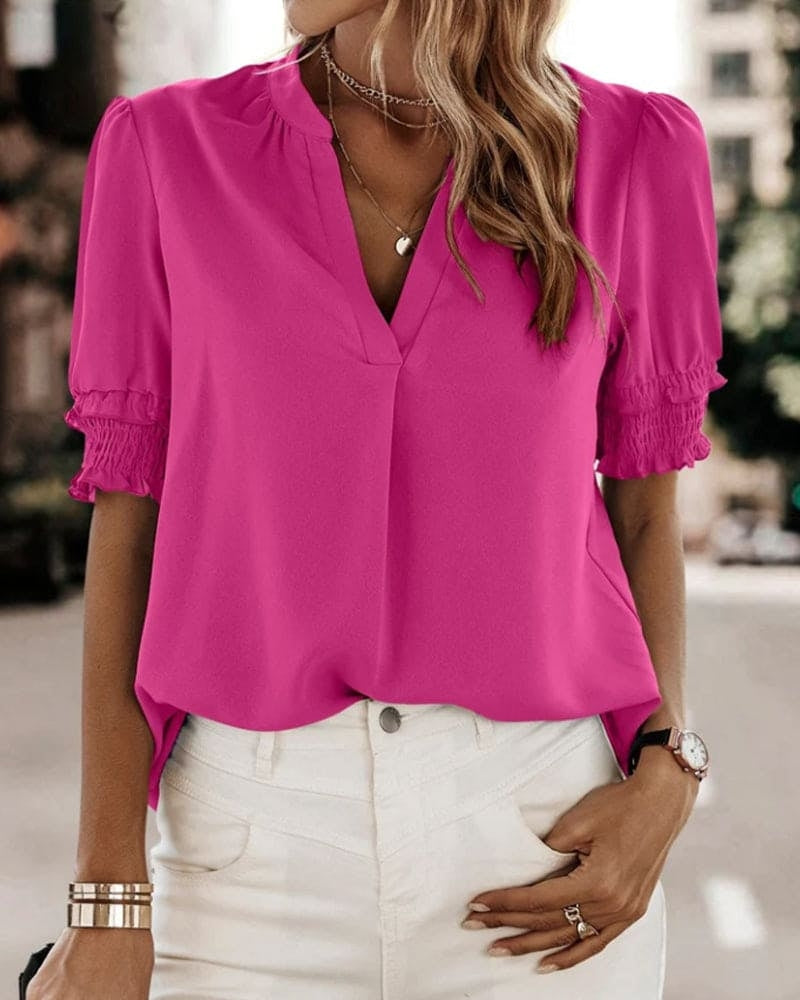 Blouse met een stijlvolle V-hals en trendy korte mouwen. Een veelzijdige aanvulling op je garderobe met een perfecte balans tussen casual en professioneel. Gemaakt van luchtige chiffon en duurzaam polyester voor comfort en stijl. Voorzien van een flatterende V-hals, pofmouwen en een losse pasvorm voor bewegingsvrijheid. Maattabel beschikbaar voor borst, lengte en mouwen.