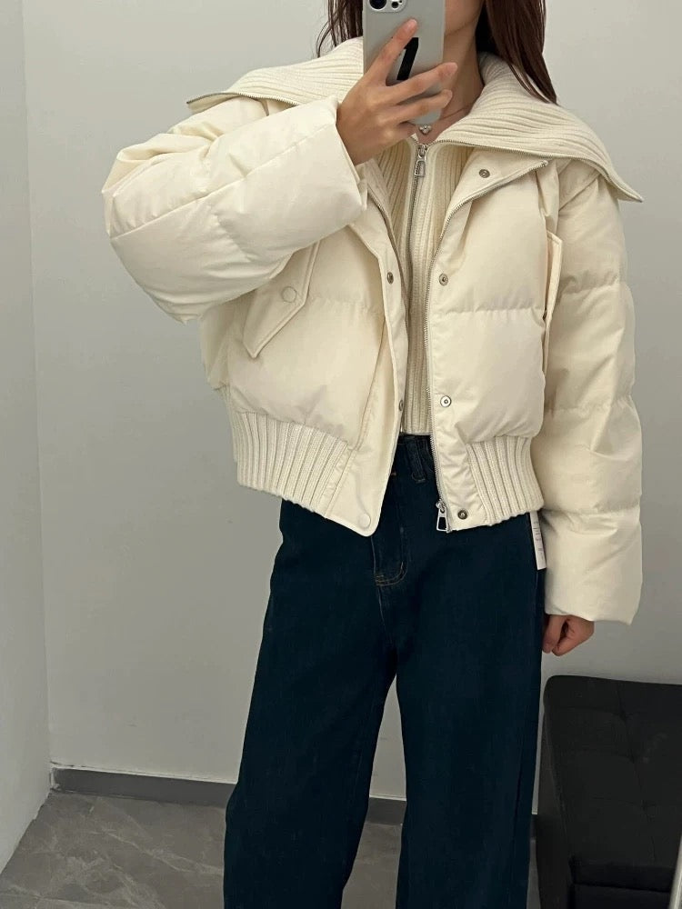 crème puffer jas dames gedragen bij een donkere wide leg jeans