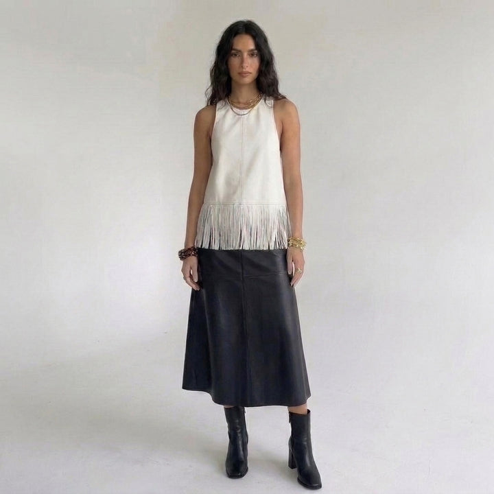 Off-white kunstleren franjetop gecombineerd met een zwarte leren midirok en enkellaarsjes