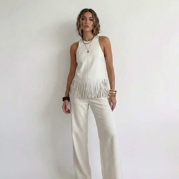 Off-white halter top van kunstleer met franjes, gedragen op een linnen wide leg broek